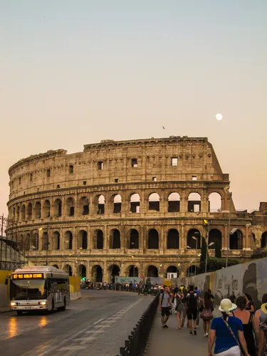 bus riding next to the colosseum